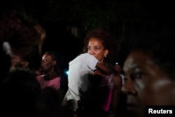 Una madre con su hijo en brazos protesta frente a una sede del Partido Comunista en La Habana, el 29 de septiembre de 2022. (REUTERS/Alexandre Meneghini)