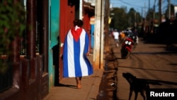 Una persona camina envuelta en una bandera cubana, en Alquízar, provincia de Artemisa. (Reuters/Tomas Bravo/Archivo)