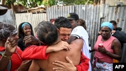 Marlon Brando Díaz (C), encarcelado por su participación en las protestas antigubernamentales de julio de 2021, saluda a sus familiares después de ser liberado de la prisión en el barrio de Guinera en La Habana el 16 de enero de 2025.&nbsp;&nbsp;YAMIL LAGE / AFP