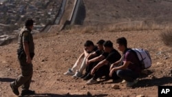 Inmigrantes irregulares detenidos tras cruzar la frontera de Estados Unidosa través de un hueco entre los dos muros que separan México del país, el 23 de enero de 2025, en San Diego. (AP/Gregory Bull).